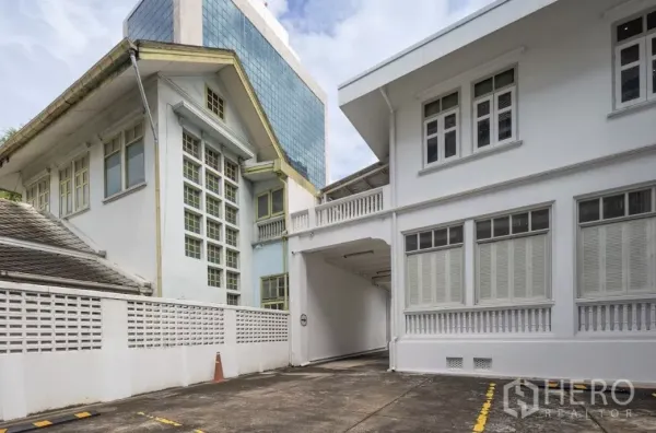 Retail Space for rent in Bang Rak, Bangkok - Side buildings with covered driveway and shuttered windows on white facade
