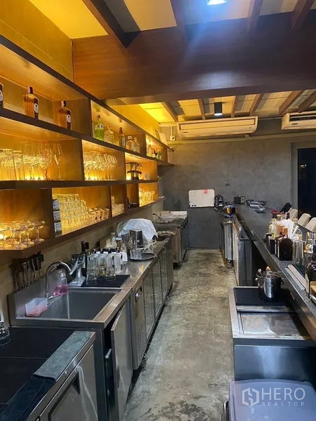 店屋 出租 - 后吧工作区设洗槽、台下冰柜与带灯玻璃架。