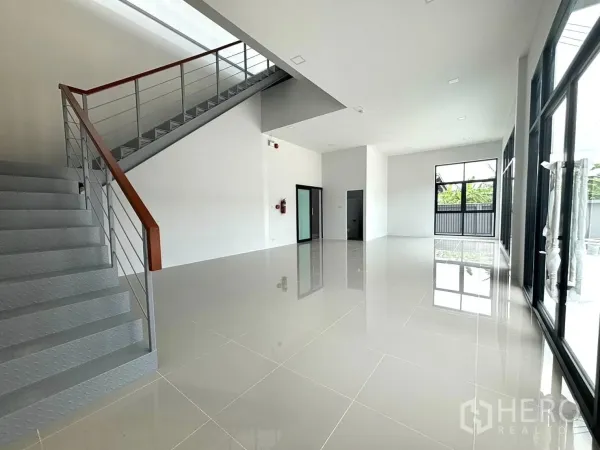 工厂 出租或出售在Bang Bo, Samut Prakan - 底层办公室与展示区，大幅落地窗和金属楼梯。