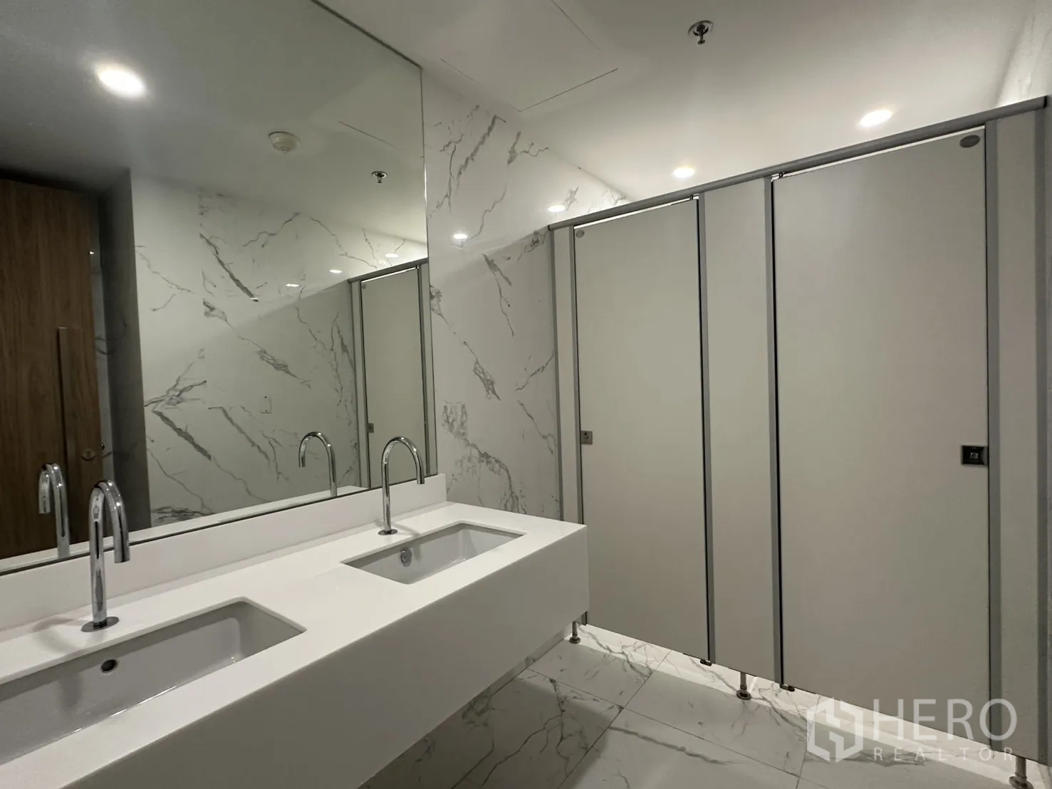 Office Space for rent in Din Daeng, Bangkok - Modern restroom with double vanity, large mirror, and partitioned stalls.