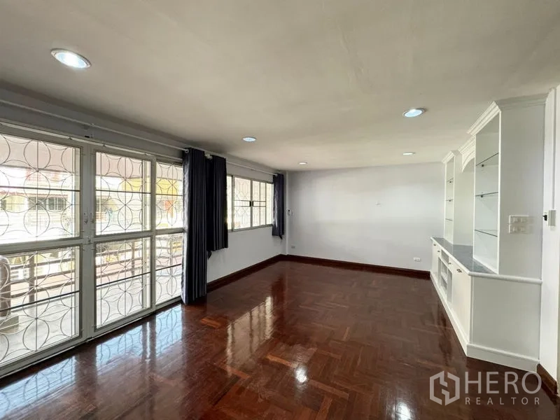 Townhouse for rent or sale in Suan Luang, Bangkok - Bright living room with parquet floor, large windows and security grilles