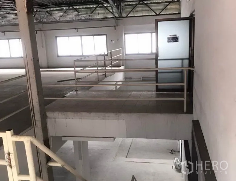 Factory for rent in Bang Bua Thong, Nonthaburi - Mezzanine landing with metal handrails and a frosted glass door leading to an office.