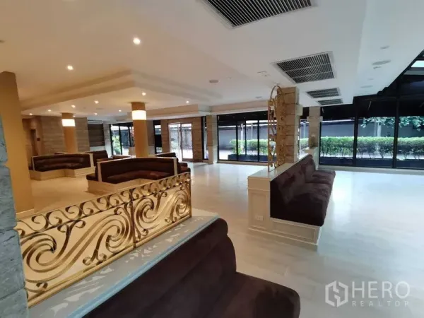Retail Space for rent in Pathum Wan, Bangkok - Seating area with decorative gold metal partition, large windows and light flooring.