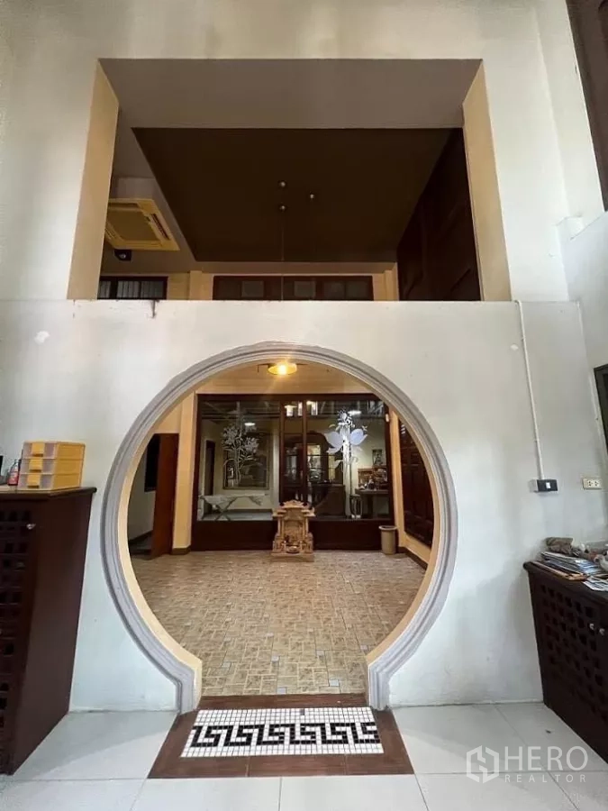 Home Office for rent in Lat Phrao, Bangkok - Circular moon-gate arch leading to a tiled hall with a high ceiling