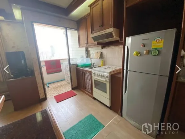 Condominium for sale in Watthana, Bangkok - Kitchen with balcony access, gas stove, sink and refrigerator with city outlooks at D.S. Tower 2.