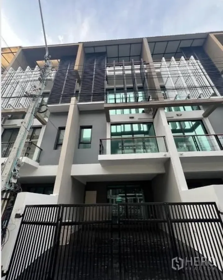 Townhouse for rent or sale in Khlong Toei, Bangkok - Another view of the modern townhouse exterior and gated driveway.