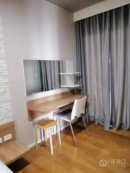 Condominium for rent in Watthana, Bangkok - Built-in dressing table with mirror and stool next to floor-length curtains