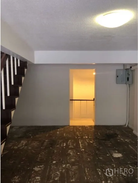 Shophouse for rent in Watthana, Bangkok - Interior floor with doorway, electrical panel and stairs, raw finish.
