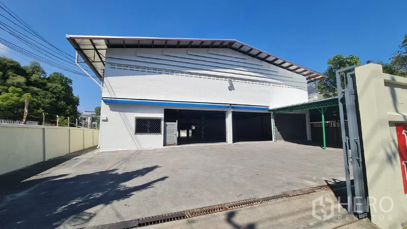 货栈 出租在Khlong Toei, Bangkok - 仓库正立面，宽阔混凝土前院与大门入口