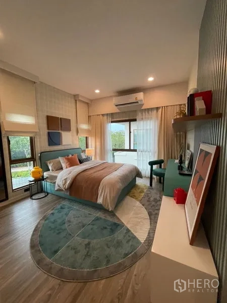 Detached House for sale in Bang Kapi, Bangkok - Spacious secondary bedroom with large windows, air conditioning and contemporary decor.