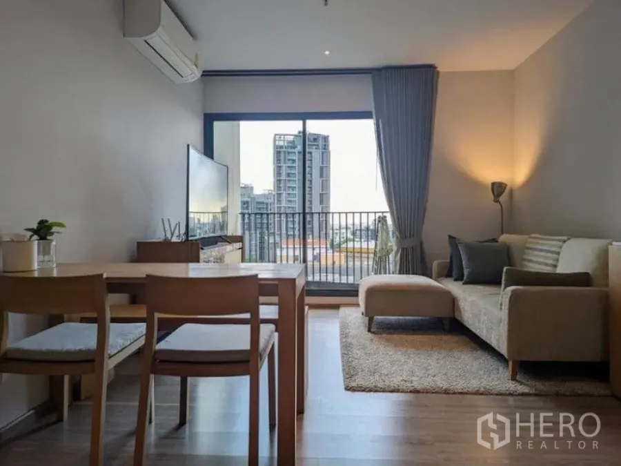 Condominium for rent in Watthana, Bangkok - Bright living and dining area with balcony and city view in a Watthana condo near BTS Ekkamai.