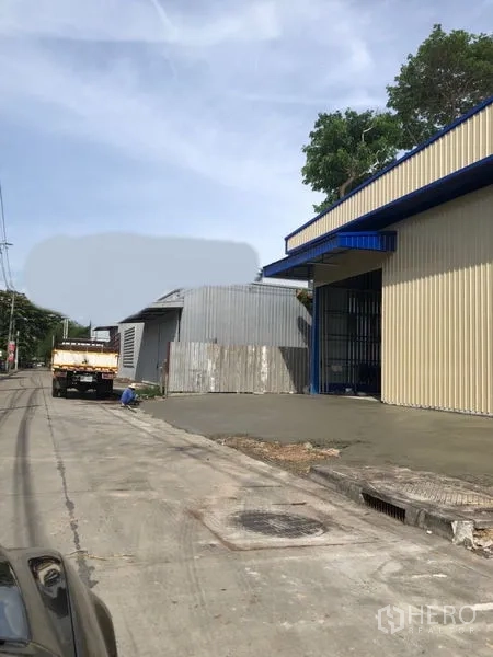Warehouse for rent in Bang Kapi, Bangkok - Metal-clad warehouse exterior with wide roller shutter and street access in Bang Kapi.