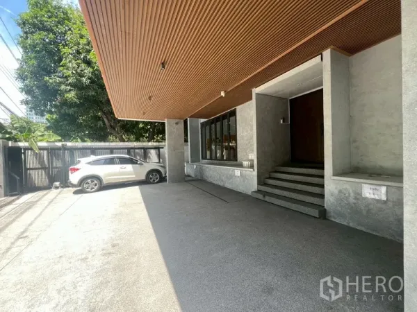 Home Office for rent or sale in Phra Khanong, Bangkok - Covered carport and main entrance with wood ceiling and steps.