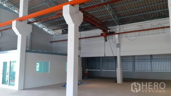 Factory for rent in Krathum Baen, Samut Sakhon - Factory hall showing overhead crane beam, tall support columns and an attached office block.