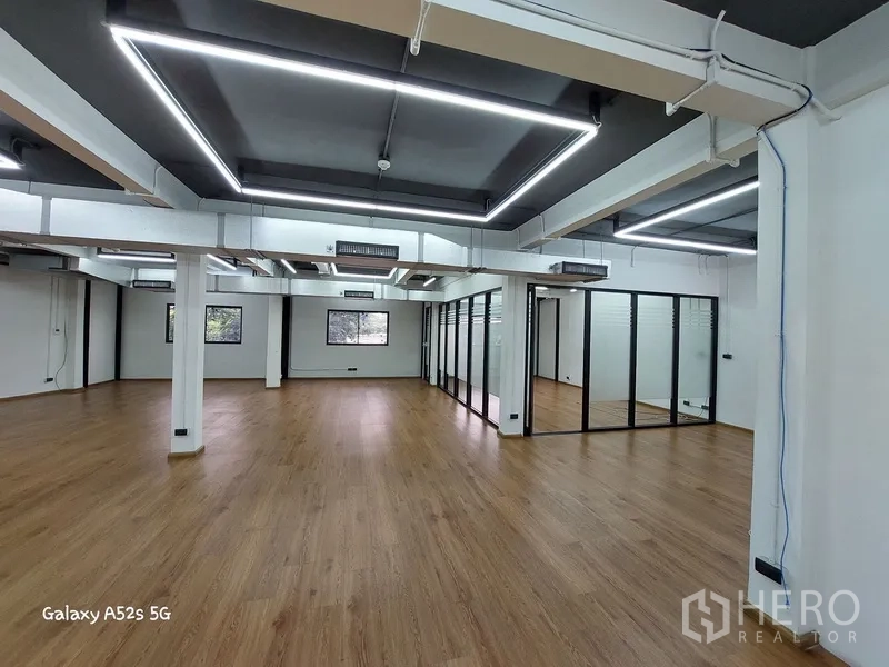 带办公室的家 出租在Khlong Toei, Bangkok - 开放式办公室，转角玻璃会议室，多扇窗可见绿景。