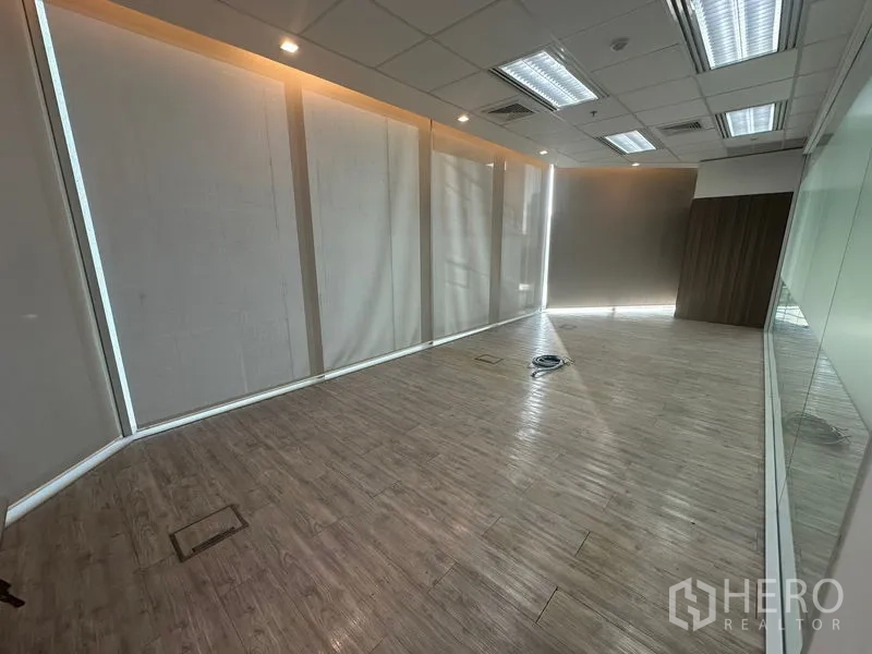 Office Space for rent in Khlong Toei, Bangkok - Private office with wood-look floors, ceiling lights, and blackout blinds.