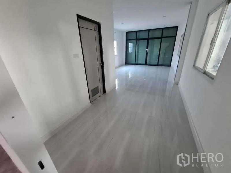 Warehouse for rent or sale in Bang Phli, Samut Prakan - Office corridor with door and glass partition opening to work area.