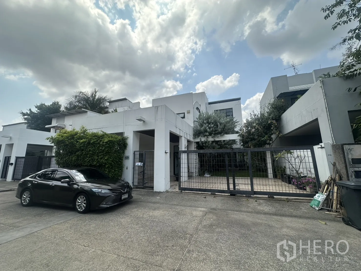 Detached House for rent in Watthana, Bangkok - Modern white detached house exterior with gated driveway.
