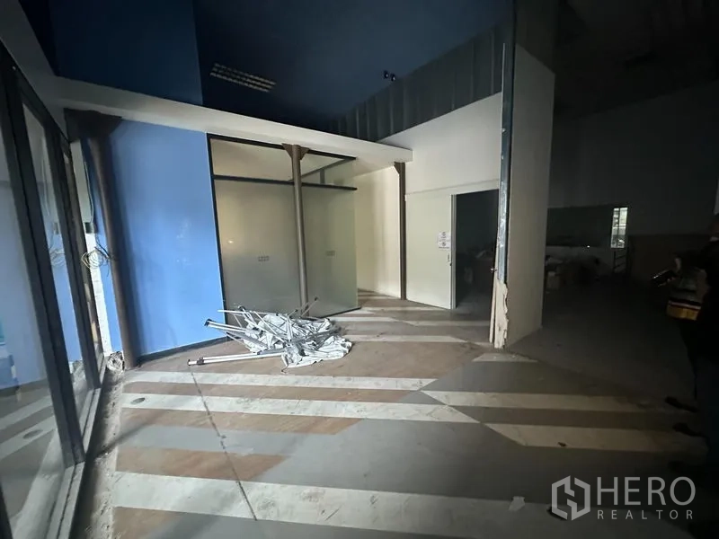 办公空间 出租在Khlong Toei, Bangkok - 带蓝色强调墙的接待区，磨砂玻璃隔间与条纹地面，处于可改造状态。