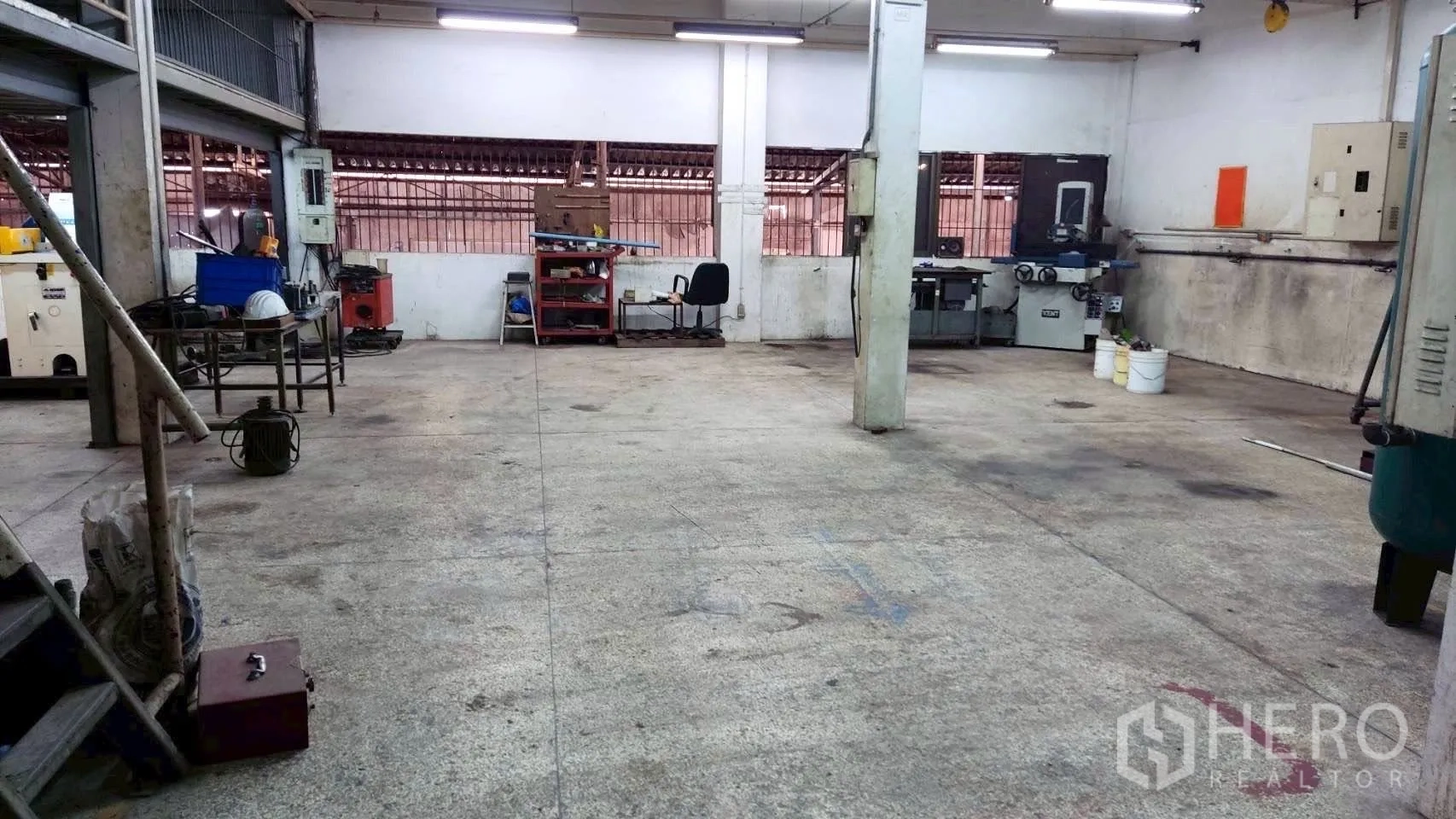 Factory for sale in Lat Krabang, Bangkok - Industrial workspace with columns, tools, and machinery arranged along the walls.