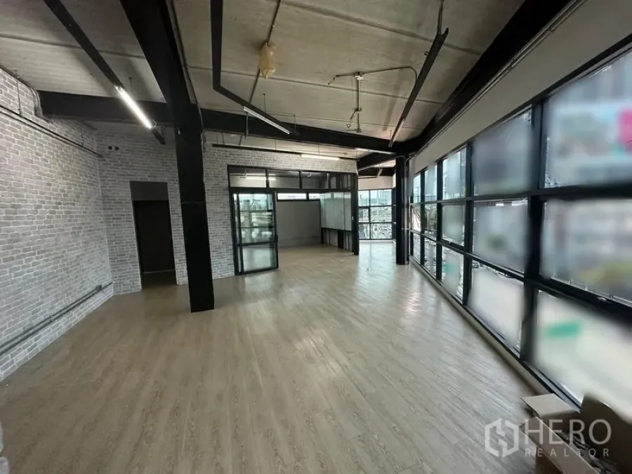 Office Space for rent in Chatuchak, Bangkok - Open-plan office featuring long window wall, exposed beams, and light wood flooring.