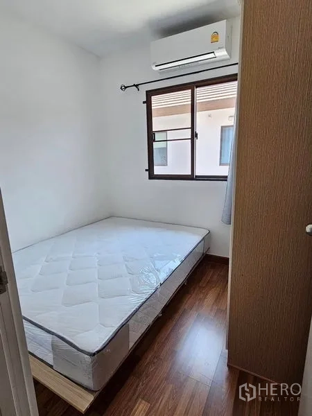Townhouse for rent - Additional bedroom with air conditioning, window and warm-tone wood flooring.