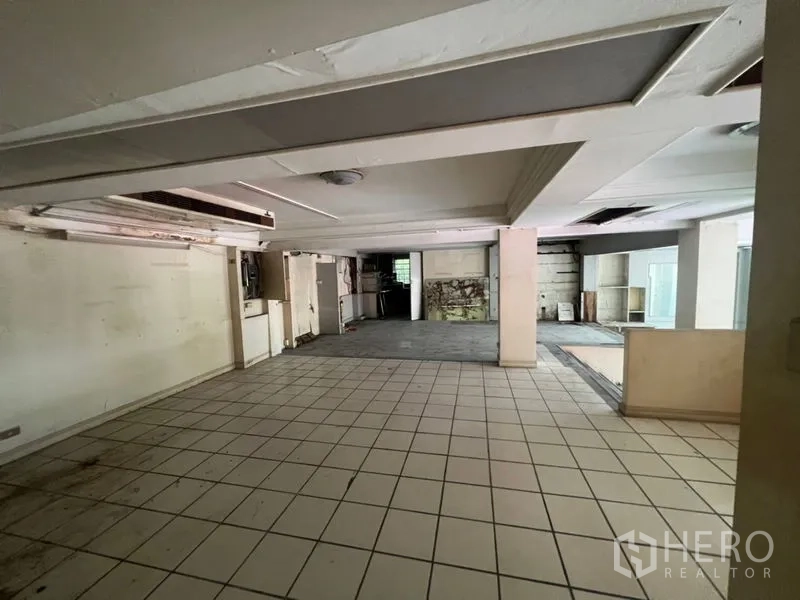 Retail Space for rent in Watthana, Bangkok - Large open trading floor with columns and varied flooring, renovation-ready.