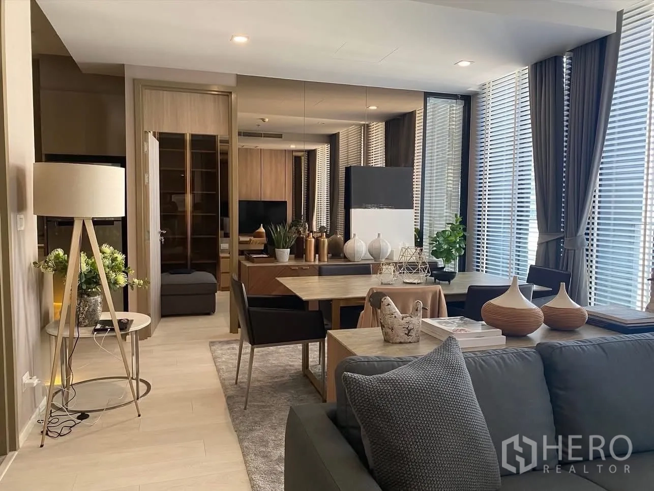 Condominium for rent in Pathum Wan, Bangkok - Open living and dining space with large windows, TV feature wall, and modern furnishings.
