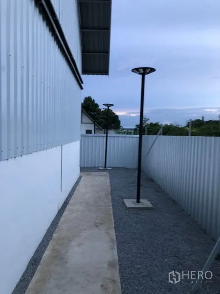 货栈 出租在Bueng Kum, Bangkok - 仓库侧边碎石步道，周界围栏与庭院灯