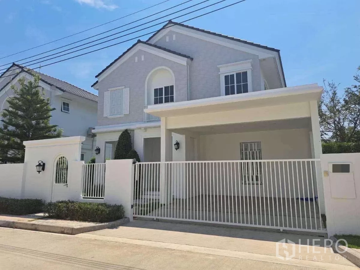 Detached House for rent in Bang Phli, Samut Prakan - Two-storey detached house exterior with gated carport and white fence on a sunny day