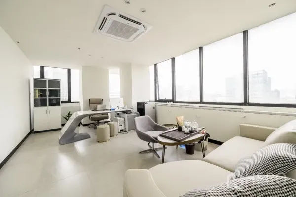 Office Space for rent or sale in Huai Khwang, Bangkok - Corner executive office with sofa seating, desk and wide city-view windows.