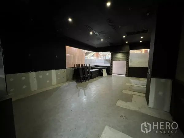 Retail Space for rent - Spacious dark-ceiling sales or dining area with downlights, roller shutter and large internal windows.