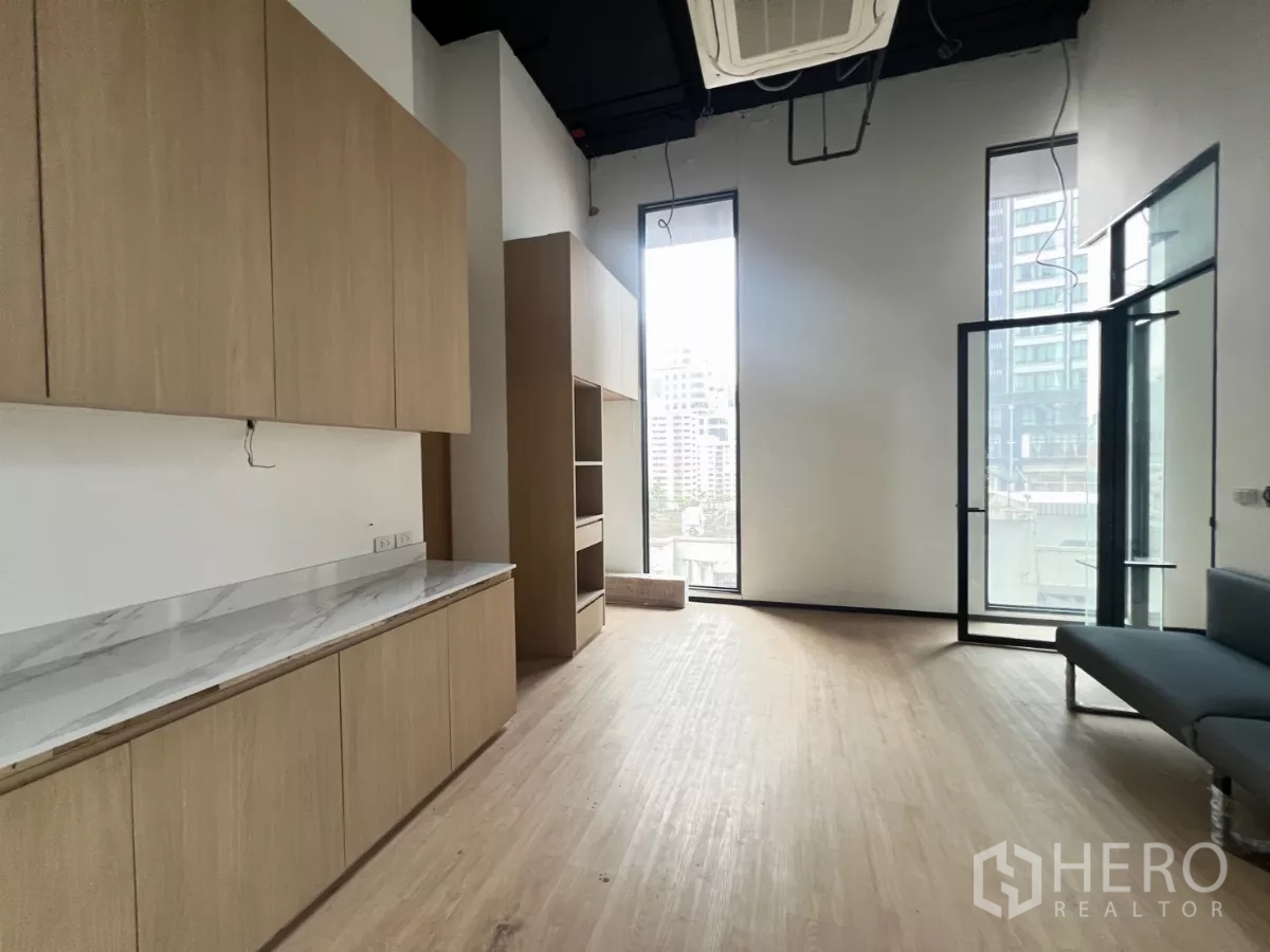 Retail Space for rent - Bright retail studio featuring built-in wood cabinets, tall windows and cassette AC.
