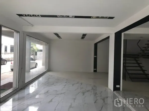 Retail Space for rent in Watthana, Bangkok - Bright corner retail space with floor-to-ceiling windows and glossy marble-look tiles.