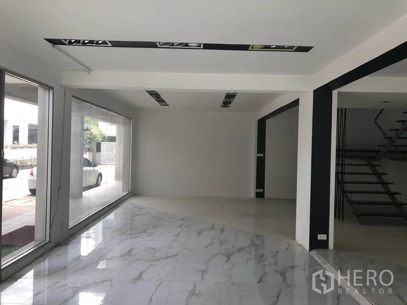 Retail Space for rent in Watthana, Bangkok - Bright corner retail space with floor-to-ceiling windows and glossy marble-look tiles.