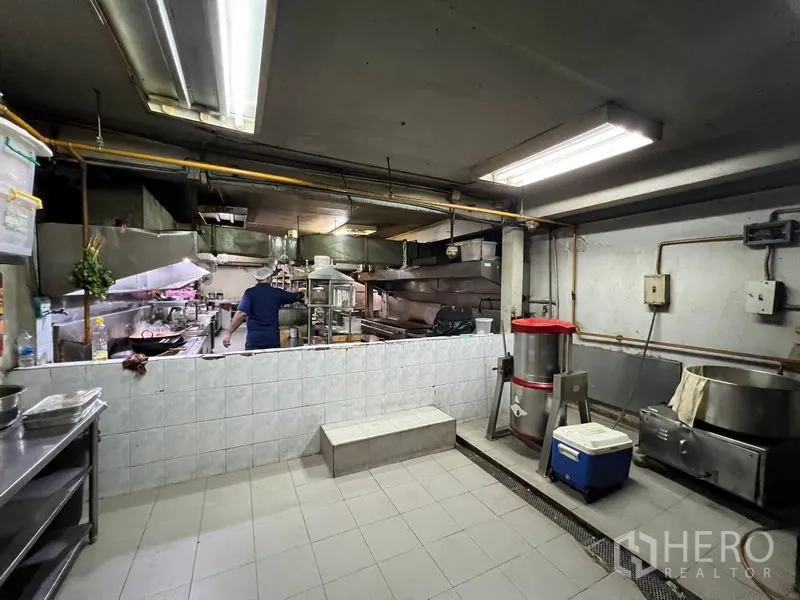 Retail Space for rent or sale in Khlong Toei, Bangkok - Commercial kitchen fitted with stainless equipment, exhaust hoods and tiled prep area.