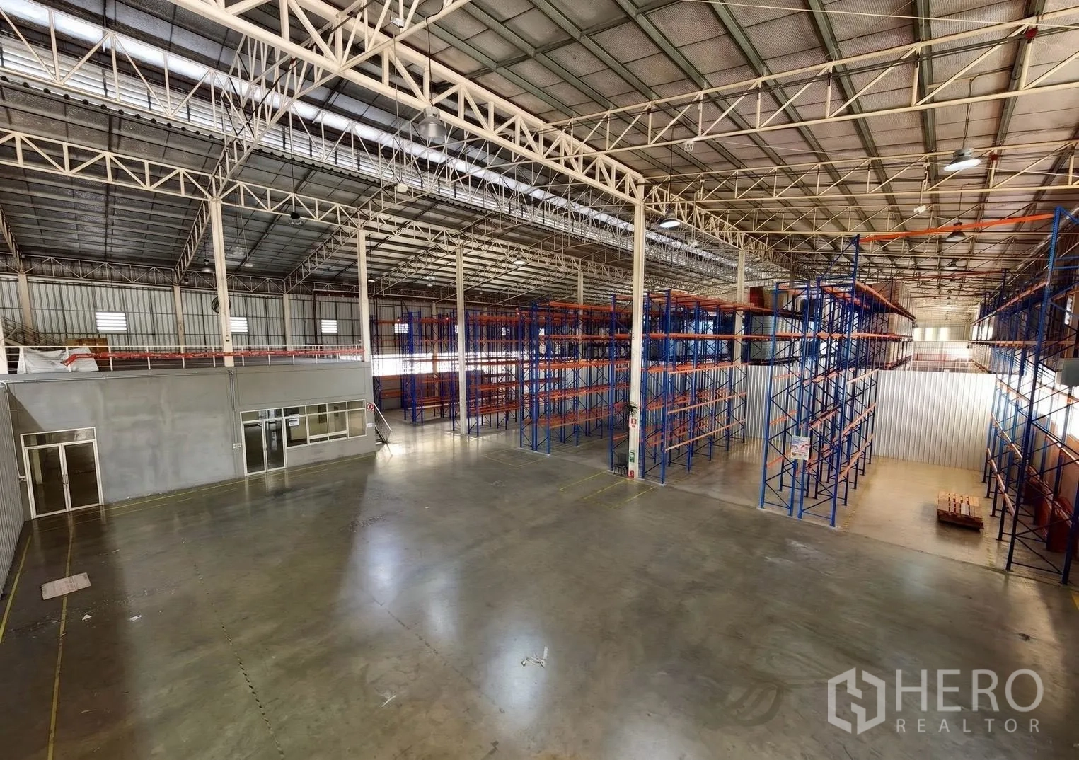 仓库 for rent in Bang Sue, Bangkok - 室内视角：钢结构屋顶、抛光地面、办公室与托盘货架。