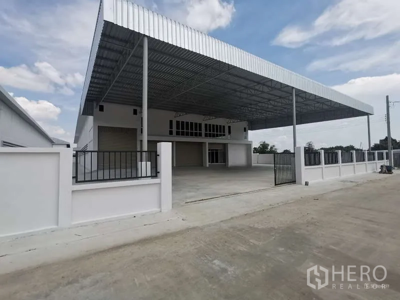 Factory for rent or sale in Bang Bo, Samut Prakan - Gated modern factory with a large steel canopy and spacious concrete yard.