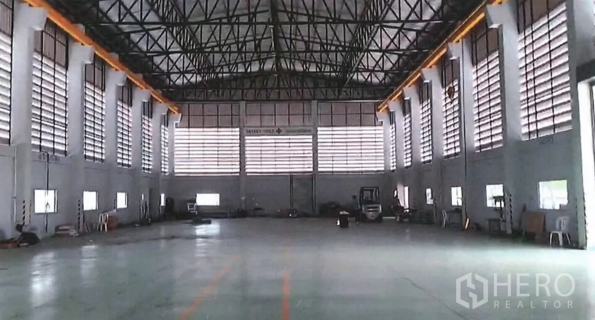 Factory for sale in Lat Lum Kaeo, Pathum Thani - Spacious production hall with high ceiling, steel trusses, louvered windows, and overhead crane rails.