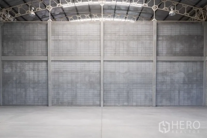 Factory for rent in Mueang Samut Sakhon, Samut Sakhon - Spacious warehouse interior with high concrete partition walls and smooth industrial floor.
