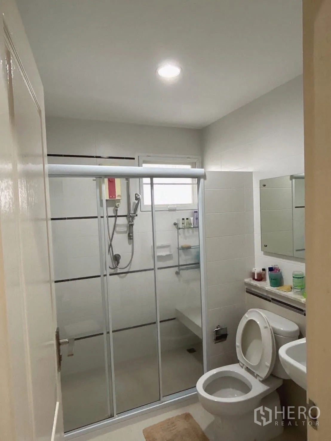 Detached House for sale in Bang Kapi, Bangkok - Modern bathroom with glass shower enclosure, toilet, and vanity.