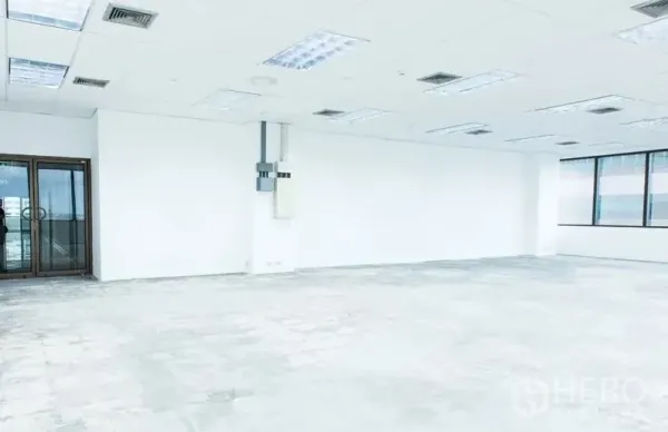 办公空间 出租在Bang Na, Bangkok - 未配家具的办公室，玻璃双开门、电箱、白墙与网格吊顶照明。