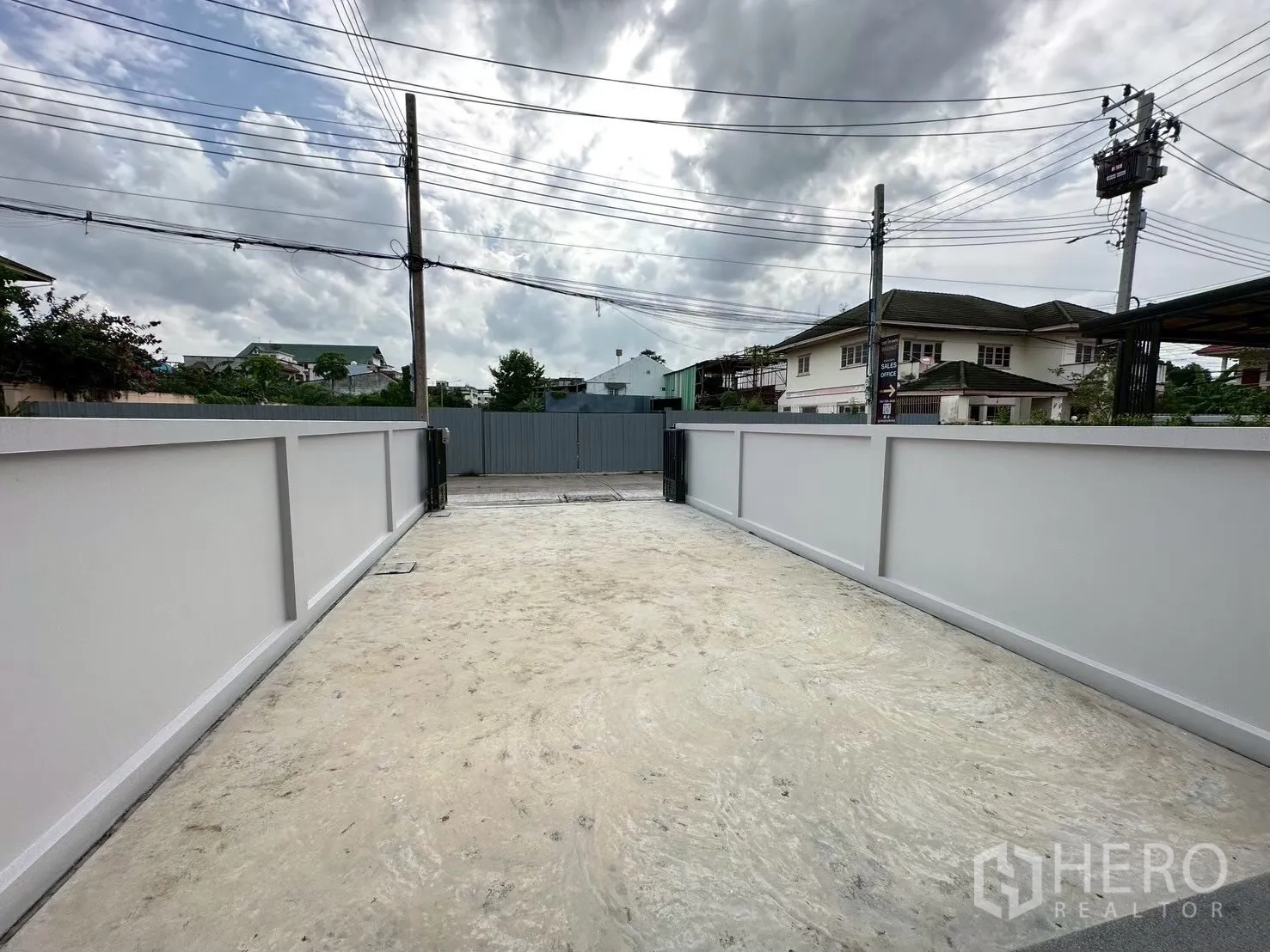 Home Office for rent in Lat Phrao, Bangkok - Private gated driveway with high walls and a wide concrete parking area.