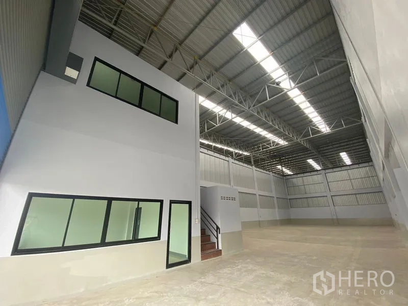 货栈 出租在Pathum Thani - 仓库内部，高挑屋顶、天窗采光与内置办公区。