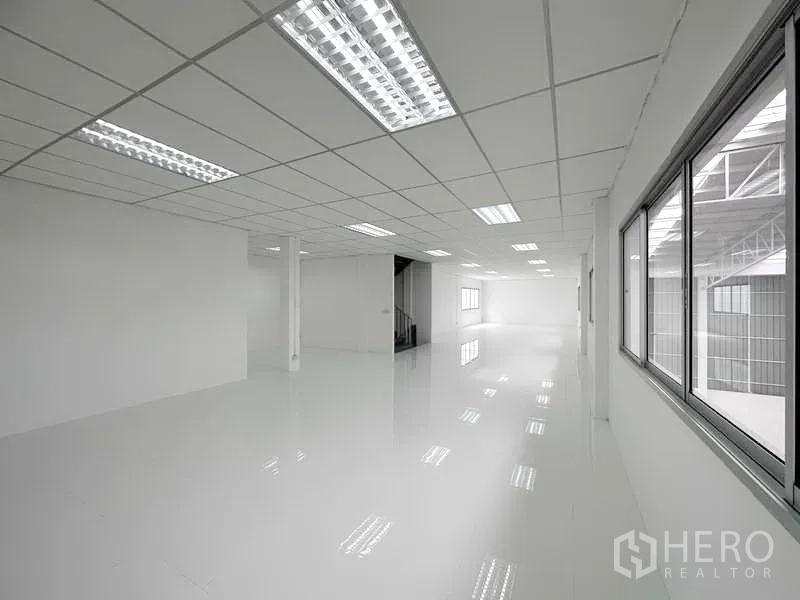 Factory for rent in Pathum Thani - Modern office level with white tile flooring and staircase access.
