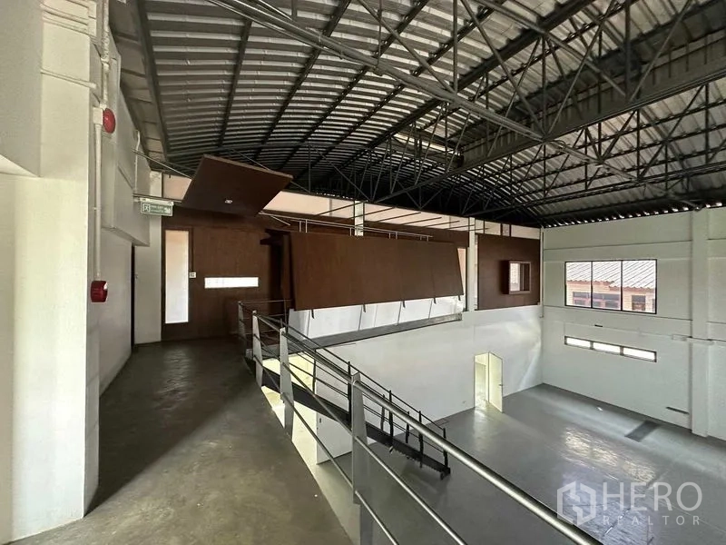 Warehouse for rent in Phra Khanong, Bangkok - Upper corridor beside mezzanine offices under a steel truss roof in the warehouse hall.