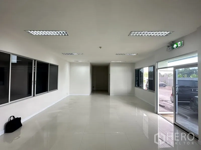 Factory for rent in Bang Phli, Samut Prakan - Office lobby with wide windows, glossy tiled floor and a glass door opening to the parking area.