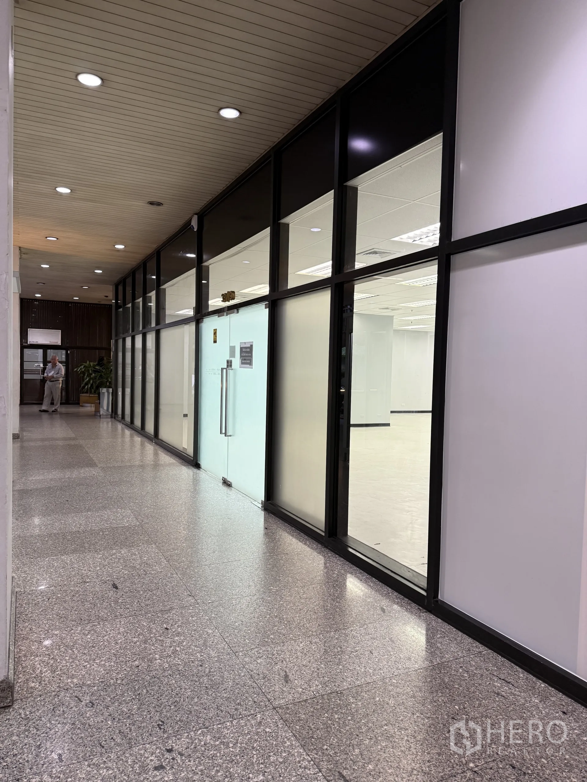 Retail Space for rent in Bang Rak, Bangkok - Building corridor with glass storefront and double glass doors leading into the unit.