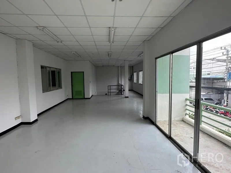 工厂 出租在Khlong Luang, Pathum Thani - 二层办公走道带大推拉玻璃门，连接露台并俯瞰停车区。