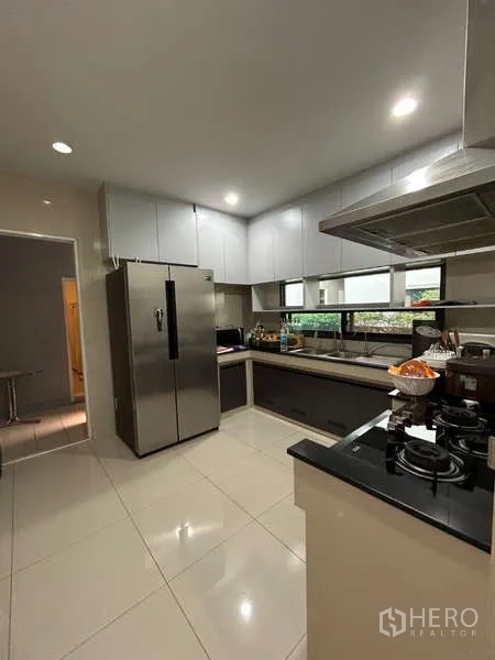 Detached House for rent in Bang Kapi, Bangkok - Functional Thai kitchen with gas hob, stainless refrigerator, and window light.